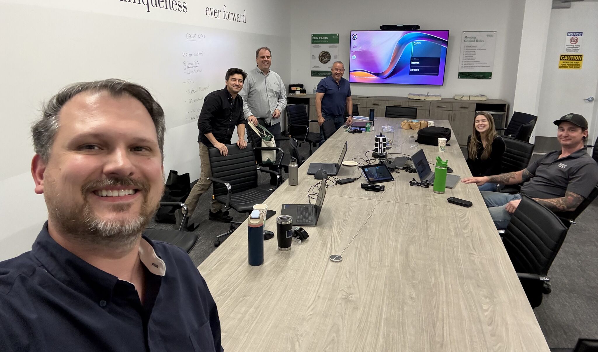 Jason Dixon working with a team around laptops and screens in a planning session