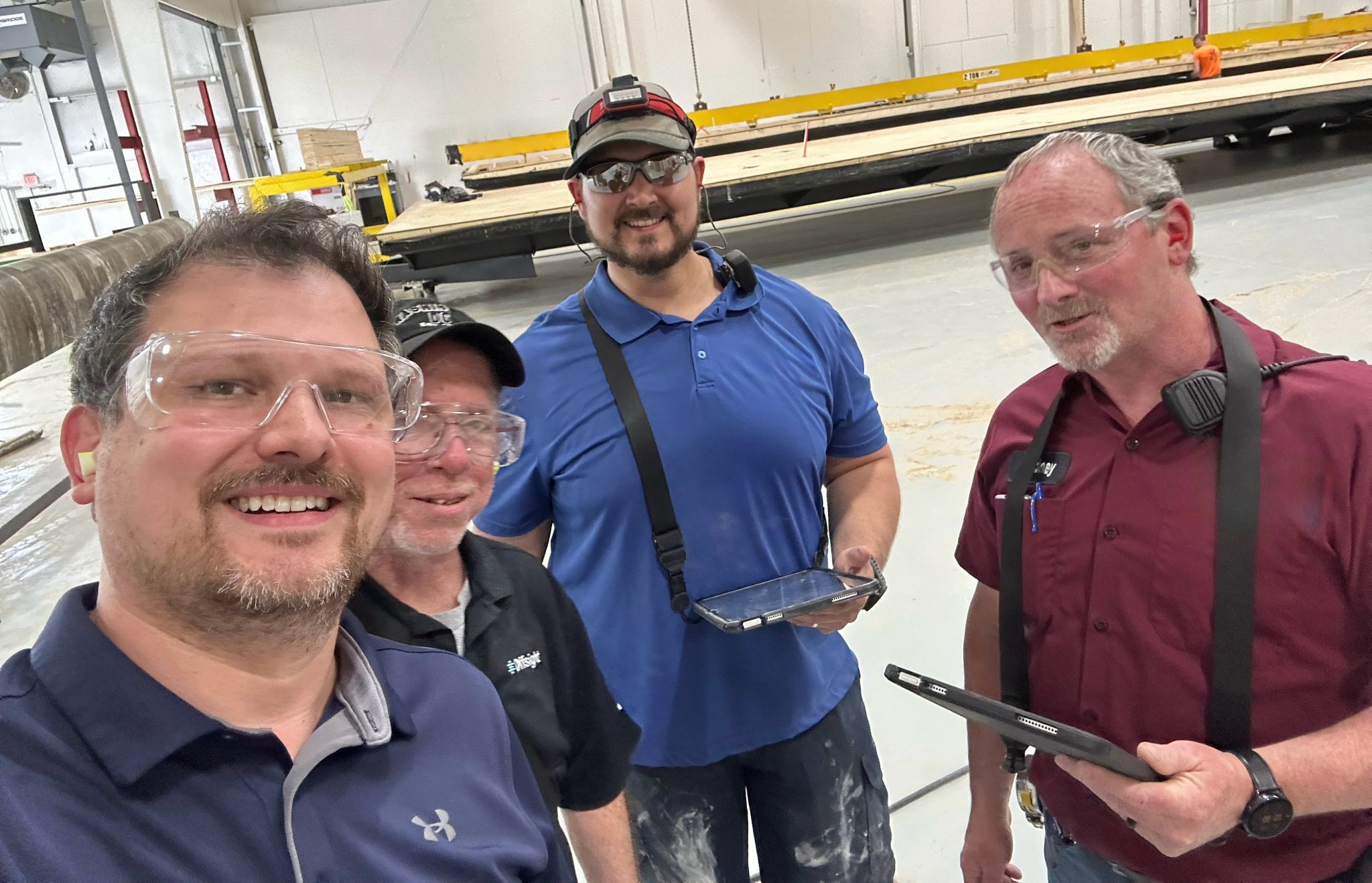 Jason Dixon with quality and production leads reviewing tablets on a panelized manufacturing line